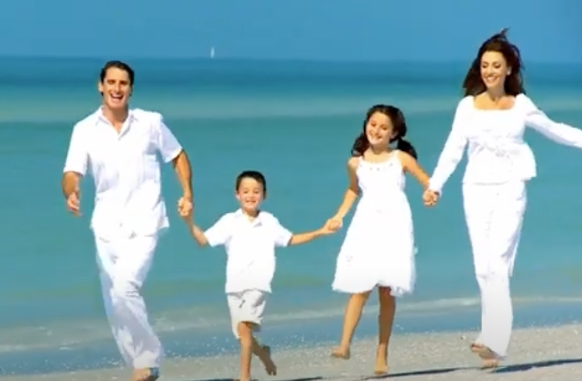 Family Skipping On Their Vacation On Beach